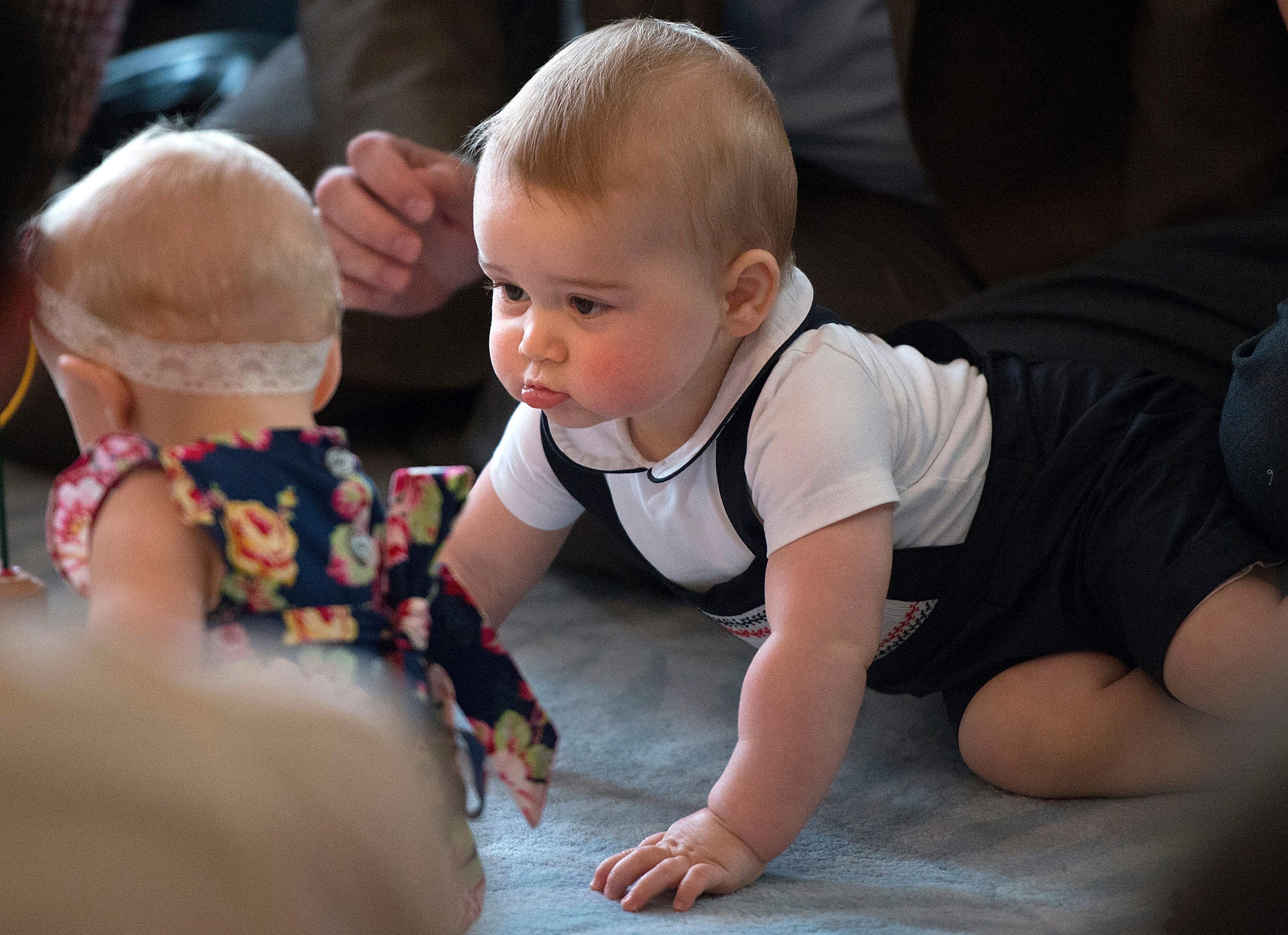 Prince George, son of Britain's Prince William and his wife Catherine, the Duchess of Cambridge, looks at other babies in Wellington