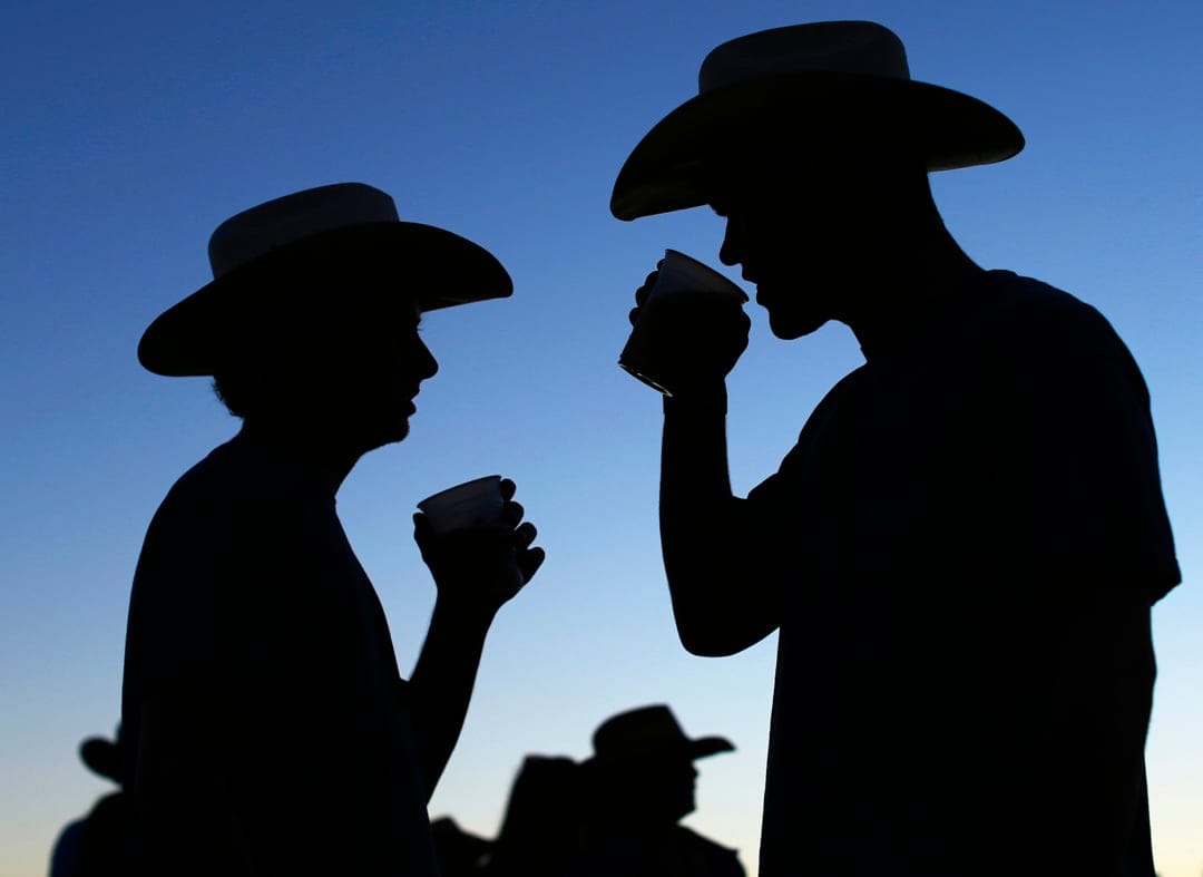 Country music fans drink beer as night falls during final day of Stagecoach country music festival in Indio