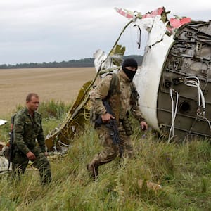 Pro-Russian fighters walk at the site of a crashed Malaysia Airlines passenger plane near the village of Hrabove, Ukraine, eastern Ukraine Friday, July 18, 2014. (Dmitry Lovetsky, Associated Press)