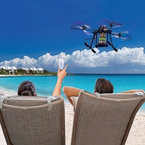 A couple on a beach resort recives a champagne delivery by a drone