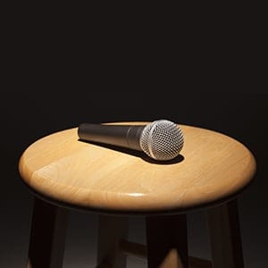 Microphone Laying on Wooden Stool Under Spotlight Abstract.