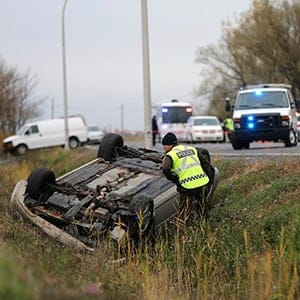 Surete du Quebec officer investigates an overturned vehicle in Saint-Jean-sur-Richelieu