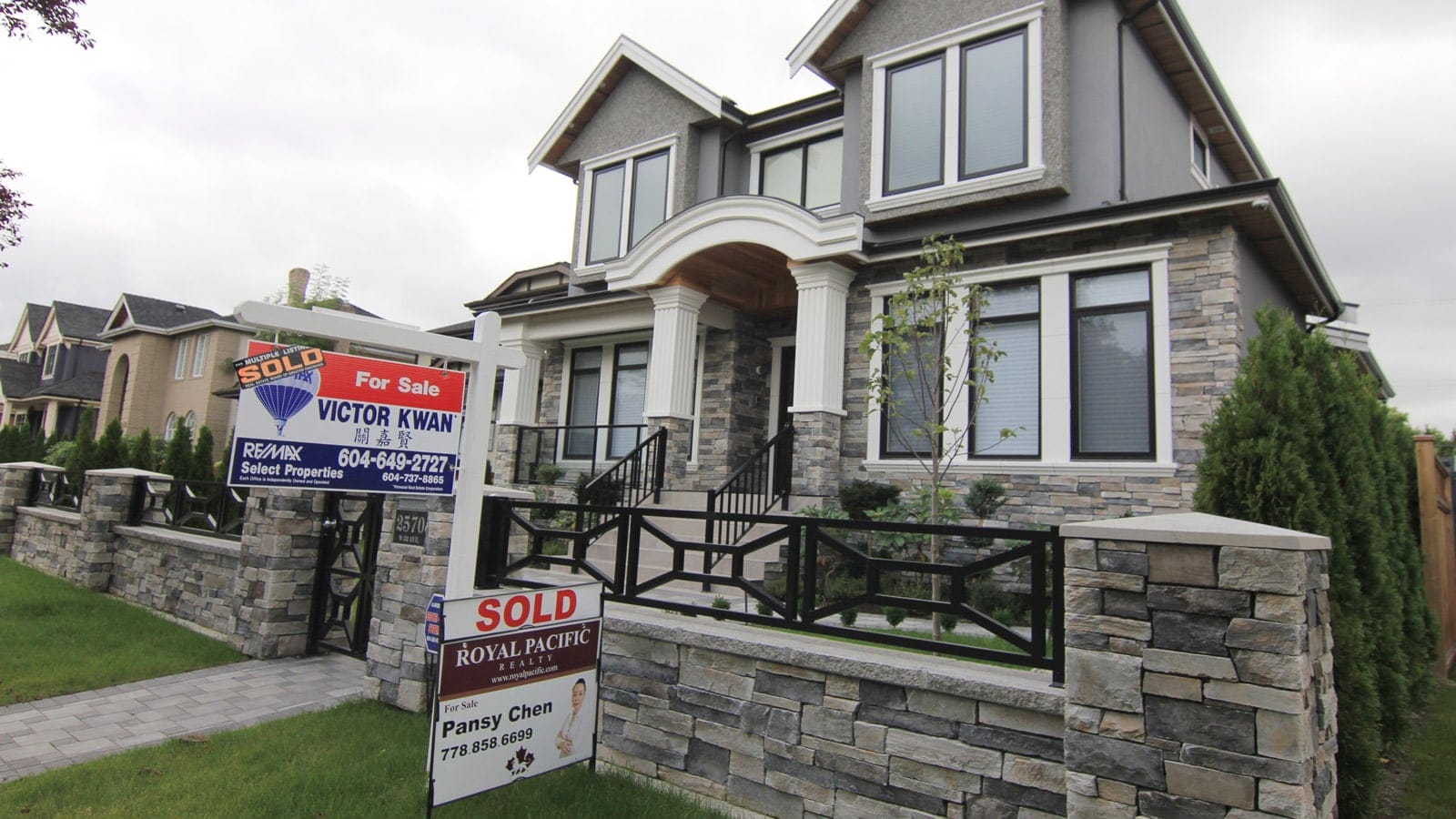 Realtors' signs are hung outside a newly sold property in a Vancouver neighborhood