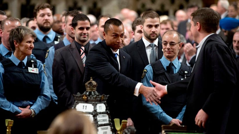 House of Commons Speaker Andrew Scheer shakes hands with Const. Samearn Son as other security members look on in the House of Commons as they are honoured for their efforts during the October shooting on Parliament Hill, Thursday December 11, 2014 in Ottawa. (Adrian Wyld/CP)