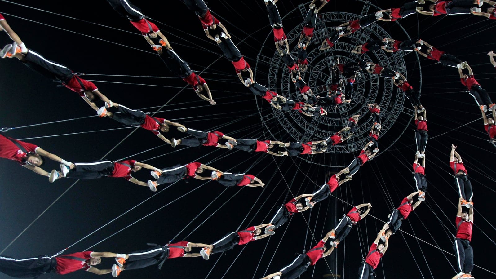 Students of Shaolin Tagou Martial Arts School are suspended in mid-air as they practise in a dress rehearsal for a stunt performance which is part of the opening ceremony of the 2014 Nanjing Youth Olympic Games, at a stadium in Nanjing