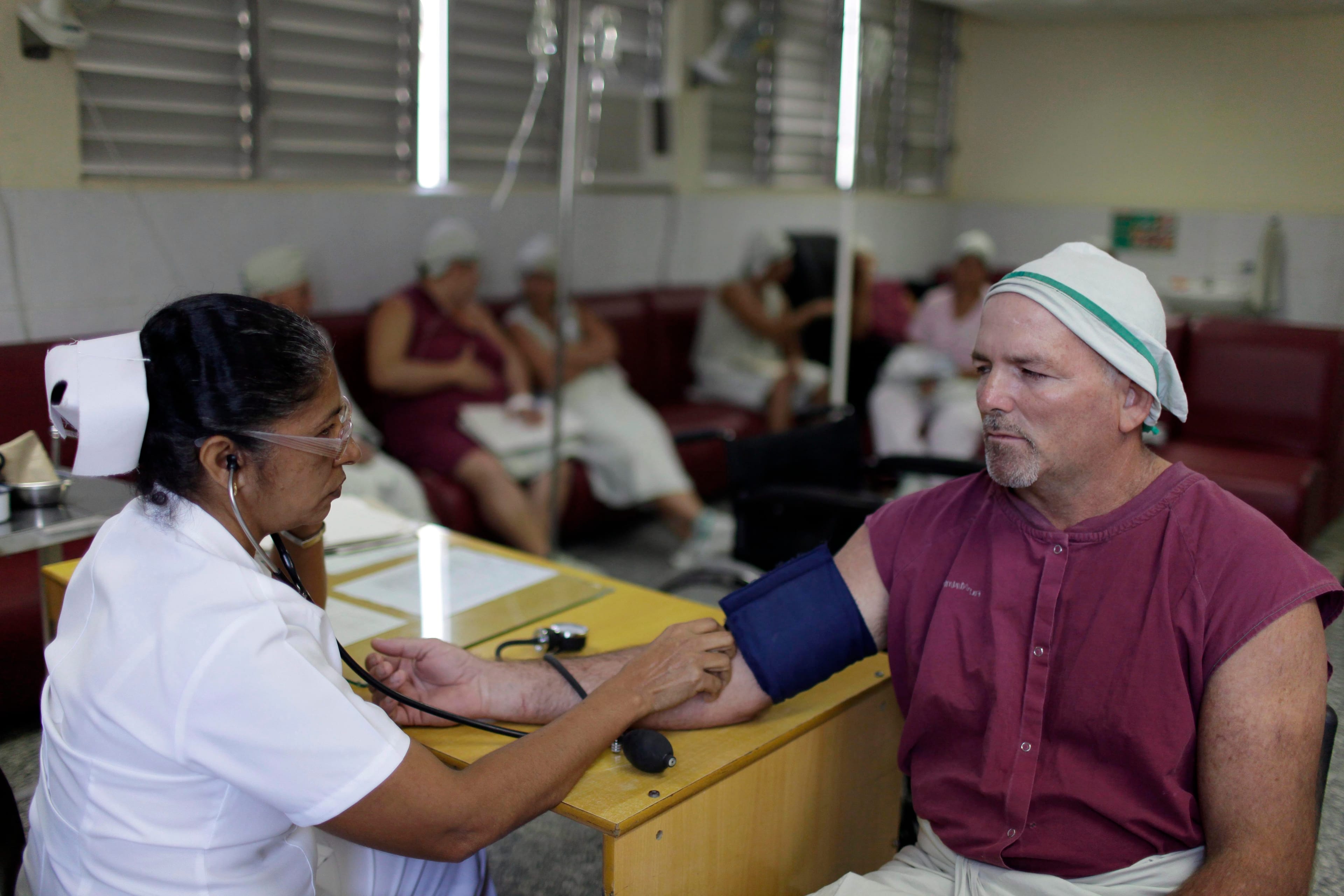 In this Feb 8, 2013 photo, a nurse checks a patient's blood pressure at the Dr. Gustavo Lima Aldereguía Hospital in Cienfuegos, Cuba. (AP Photo/Franklin Reyes)