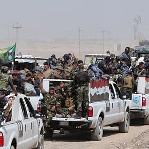 Iraqi security forces and paramilitaries deploy, on May 26, 2015, in al-Nibaie area, north-west of Baghdad, during an operation aimed at cutting off Islamic State (IS) jihadists in Anbar province before a major offensive to retake the city of Ramadi. Iraqi forces closed in on Ramadi and launched the operation dubbed Labaik ya Hussein", which roughly translates as "We are at your service, Hussein" and refers to one of the most revered imams in Shiite Islam. It will see a mix of security forces and paramilitaries move south towards the city from Salaheddin province, said Hashed al-Shaabi ("popular mobilisation" in Arabic) spokesman Ahmed al-Assadi. (AHMAD AL-RUBAYE/AFP/GETTY IMAGES)