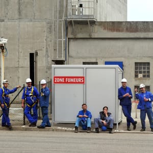 Workers smoke a cigarette during a break on October 14, 2009 at the French electricity group EDF (Electricite de France) nuclear plant in Flamanville, western France. (Mychele Daniau/AFP/Getty Images)