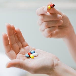 Woman taking vitamins and supplements.  Tom Merton/Getty Images