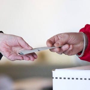 An election official hands back to a voter her marked ballot to place in the ballot box so she can cast her vote for the federal election at a polling station on Toronto's Ward Island   on Monday May 2, 2011. Elections Canada scrambled to staff dozens of polling stations across Canada on May 2 when the people it hired called in sick, slept late, took unauthorized meal breaks — or quit in a huff over working conditions. THE CANADIAN PRESS/Chris Young