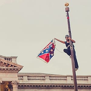 Bree Newsome takes down the Confederate Flag from a pole at the Statehouse in Columbia, South Carolina, June 27, 2015. Newsome was later arrested for her action. REUTERS/Adam Anderson Photo  TPX IMAGES OF THE DAY   NO SALES. NO ARCHIVES. FOR EDITORIAL USE ONLY. NOT FOR SALE FOR MARKETING OR ADVERTISING CAMPAIGNS. MANDATORY CREDIT. Adam Anderson/Reuters