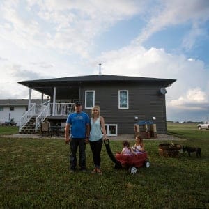 RESTON, MANITOBA: July 13, 2015 -- ( L to R) Chad Hack, his wife Danielle and their daughters Novalee, 3, and Kylie, 6, on their Reston, Manitoba property which they purchased for $10 on the agreement that they would stay in the community for at least five years. Photograph by Michelle Siu.