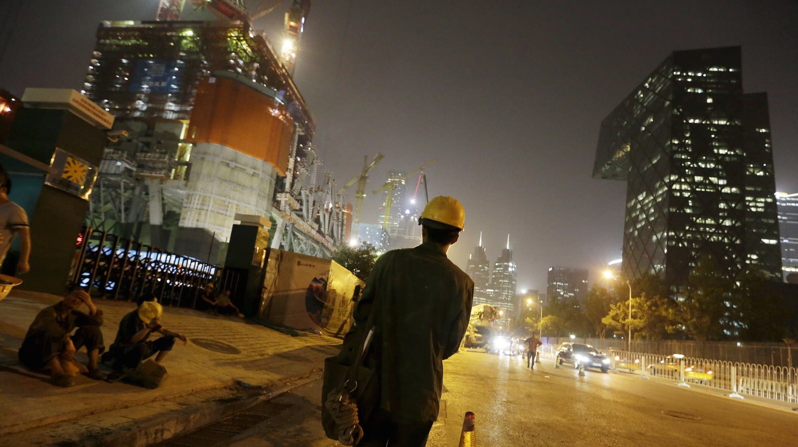 Workers wait for a shuttle bus to leave after a day's work outside a construction site in Beijing's central business district June 24, 2015. U.S. President Barack Obama is expected to press Chinese leader Xi Jinping during the latter's state visit later this month on issues that have strained relations between the two countries, but his approach will be tempered because for better or worse the worldís two biggest economies are inextricably bound together. Picture taken on June 24, 2015. REUTERS/Jason Lee  - RTS1HNR