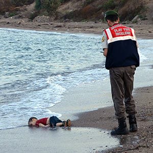 ADDS IDENTIFICATION OF CHILD   Paramilitary police officers investigate the scene before carrying the lifeless body of Aylan Kurdi, 3, after a number of migrants died and a smaller number were reported missing after boats carrying them to the Greek island of Kos capsized, near the Turkish resort of Bodrum early Wednesday, Sept. 2, 2015. The family — Abdullah, his wife Rehan and their two boys, 3-year-old Aylan and 5-year-old Galip — embarked on the perilous boat journey only after their bid to move to Canada was rejected. The tides also washed up the bodies of Rehan and Galip on Turkey's Bodrum peninsula Wednesday, Abdullah survived the tragedy. AP