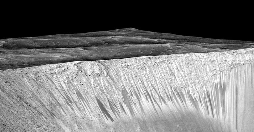 Dark narrow streaks called recurring slope lineae emanating out of the walls of Garni crater on Mars. The dark streaks here are up to few hundred meters in length. They are hypothesized to be formed by flow of briny liquid water on Mars. The image is produced by draping an orthorectified (RED) image (ESP_031059_1685) on a Digital Terrain Model (DTM) of the same site produced by High Resolution Imaging Science Experiment (University of Arizona). Vertical exaggeration is 1.5. (NASA/JPL/University of Arizona)