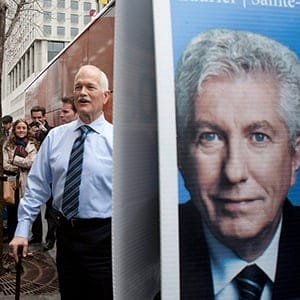 NDP Leader Jack Layton walks by a Bloc Quebecois Leader Gilles Duceppe sign outside of the campaign bus Saturday, April 23, 2011  in Montreal. Layton held a big rally in the riding of Laurier-Sainte-Marie the Bloc Quebecois leader's home riding. (Jacques Boissinot/CP)