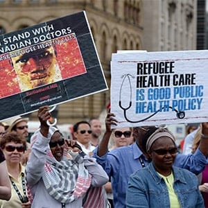 Health care providers and supporters hold a rally to protest federal cuts to refugee care on Parliament Hill in Ottawa, Monday, June 16, 2014. (Sean Kilpatrick/CP)