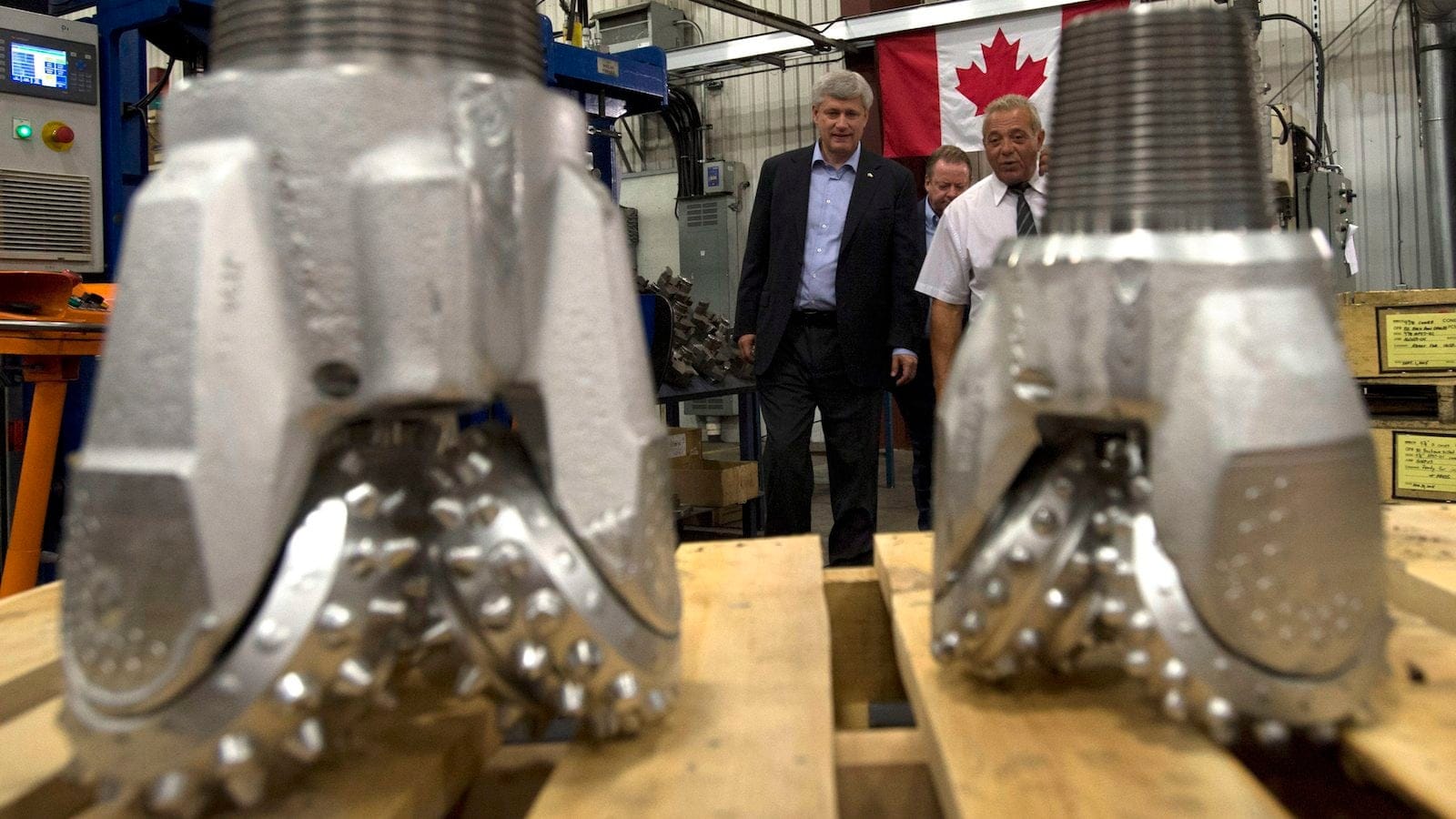 Conservative leader Stephen Harper speaks with Joe Guido, President of Premier Mining Products as he is shown drill bits during a campaign stop in North Bay, Ont., on Wednesday, September 2, 2015. THE CANADIAN PRESS/Adrian Wyld