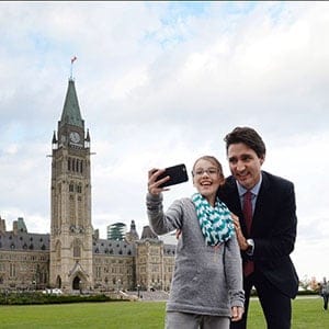 Prime minister designate Justin Trudeau stops to have a selfie taken as he makes his way from Parliament Hill to the National Press Theatre to hold a press conference in Ottawa on Tuesday, October 20, 2015. (Sean Kilpatrick/CP)