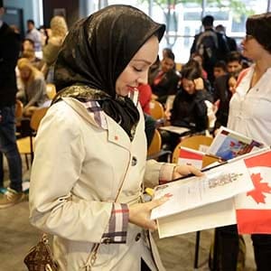 A young woman looks at her official citizenship document that she received at a Vancouver ceremnoy on Oct 6th, 2015. (Photograph by Brian Howell)