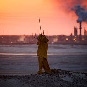A scarecrow, used to deter birds from the tailings pond, stands near the Syncrude Canada Ltd. upgrader plant of the company's mine at dusk in the Athabasca Oil Sands near Fort McMurray, Alberta, Canada, on Tuesday, June 2, 2015. Canadian stocks rose a second day as commodities producers rallied after the price of oil climbed to the highest level this year while gold and copper led metals higher. (Ben Nelms/Bloomberg/Getty Images)