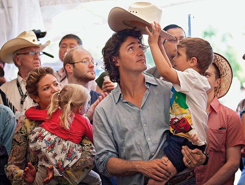 Liberal MP Justin Trudeau, centre, has his cowbay taken by his son Xavier, 4 years-old, while his wife Sophie Gregoire, second from left, holds daughet Ella-Grace, 3 years-old, while they attend the party's annual Stampede breakfast in Calgary, Saturday, July 7, 2012. This is the 100th anniversary of the Stampede.Jeff McIntosh/CP