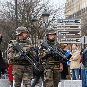 Tourists pause to take pictures as French military patrol near the Notre Dame Cathedral (not seen) the day after a series of deadly attacks in Paris, France, November 14, 2015. (Yves Herman/Reuters)