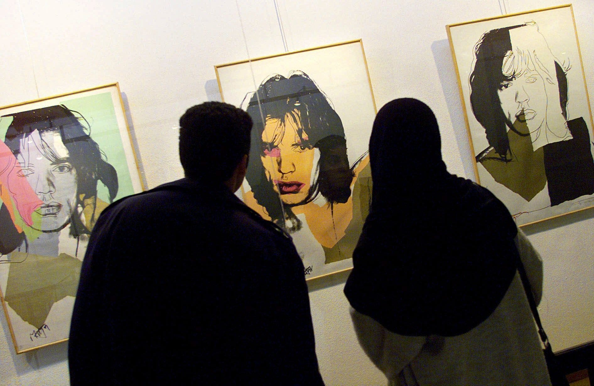 Iranians look at Andy Warhol's portraits of rock star Mick Jagger during an exhibition of Pop Art at the Museum of Contemporary Art in Tehran, Iran, Feb. 20, 2000. (AP photo/Enric Marti)