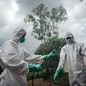 A group of young volunteers wears special uniform and wash their hands with chlorinated water ahead of sterilizing the bodies of people, died due to the Ebola virus, in Kenema, Sierra Leone on August 24, 2014. People work for 6 dollars per a day in burial and sterilizing works in Kenema where the infection of the virus is mostly seen. (Mohammed Elshamy/Anadolu Agency/Getty Images)