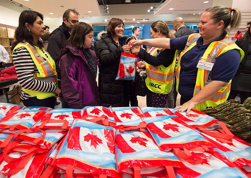 Newly-arrived Syrian refugee Anjilik Jaghlassian, centre, and her family receive winter clothes and other items at Pearson International airport, in Toronto, on Friday, Dec. 11, 2015. (Nathan Denette/CP)