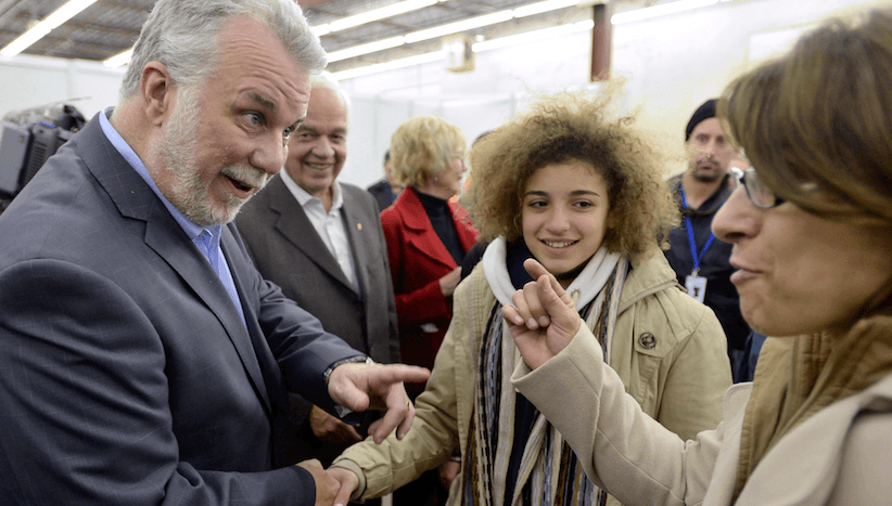 Quebec Premier Philippe Couillard greets newly-arrived Syrian refugees at a welcome centre in Montreal on Saturday, Dec. 12, 2015