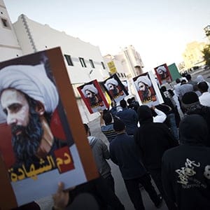 Bahraini protesters hold placards bearing portraits of prominent Shiite Muslim cleric Nimr al-Nimr during clashes with riot police in the village of Sitra, south of the capital Manama, on January 8, 2016, following a protest against his execution by Saudi authorities. (Mohammed al-Shaikh/AFP/Getty Images)