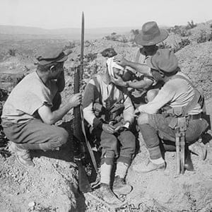 Australian soldiers dressing the head wound of an injured comrade with his first aid field dressing. (Ernest Brooks/Imperial War Museum)