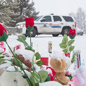 LA LOCHE, SASKATCHEWAN - JANUARY 23, 2016: Flowers are left as the RCMPA work on scene on the grounds of La Loche Community School in La Loche, SK that left 4 dead and 7 injured.  A 17-year-old boy faces four counts of first-degree murder, seven counts of attempted murder and one count of unauthorized possession of a firearm in relation to a series of shooting in the northern Saskatchewan town of only 2300 people. ( Photos  by Chris Bolin For Macleans Magazine)
