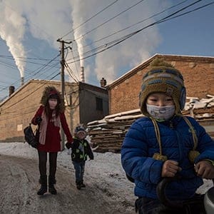 Chinese residents wear masks for protection as smoke billows from stacks in a neighborhood next to a coal fired power plant on November 26, 2015 in Shanxi, China. A history of heavy dependence on burning coal for energy has made China the source of nearly a third of the world's total carbon dioxide (CO2) emissions, the toxic pollutants widely cited by scientists and environmentalists as the primary cause of global warming. China's government has publicly set 2030 as a deadline to reach the country's emissions peak, and data suggest the country's coal consumption is already in decline. The governments of more than 190 countries are expected to sign an agreement in Paris to set targets on reducing carbon emissions in an attempt to forge a new global agreement on climate change.  (Kevin Frayer/Getty Images)