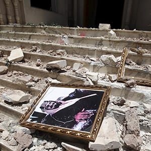 A picture of Saudia Arabia's King Salman bin Abdulaziz lies amidst debris at the damaged entrance to the headquarters of the Saudi Cultural Center in Sanaa, caused by an April 20 air strike that hit a nearby army weapons depot, in Sanaa April 21, 2015. REUTERS/Mohamed al-Sayaghi - RTX19NNH