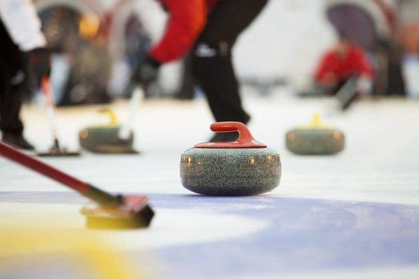 A curling stone sits on the ice. (Shutterstock)