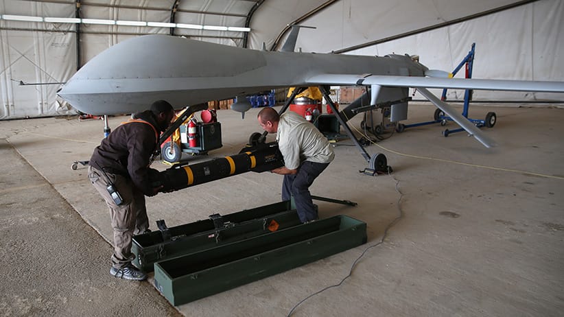 UNSPECIFIED, UNSPECIFIED - JANUARY 07:  Contract workers load a Hellfire missile onto a U.S. Air Force MQ-1B Predator unmanned aerial vehicle (UAV), at a secret air base in the Persian Gulf region on January 7, 2016. The U.S. military and coalition forces use the base, located in an undisclosed location, to launch drone airstrikes against ISIL in Iraq and Syria, as well as to distribute cargo and transport troops supporting Operation Inherent Resolve. The Predators at the base are operated and maintained by the 46th Expeditionary Reconnaissance Squadron, currently attached to the 386th Air Expeditionary Wing.  (John Moore/Getty Images)