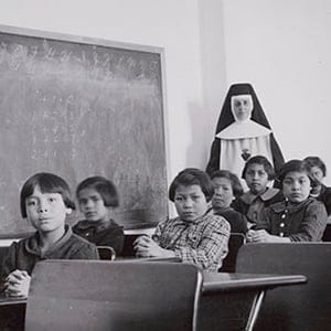 A group of female students and a nun pose in a classroom at Cross Lake Indian Residential School in Cross Lake, Manitoba in a February 1940 archive photo. A Canadian policy of forcibly separating aboriginal children from their families and sending them to residential schools amounted to "cultural genocide," a six-year investigation into the now-defunct system found on June 2, 2015. The residential school system attempted to eradicate the aboriginal culture and to assimilate aboriginal children into mainstream Canada, said the long-awaited report by the Truth and Reconciliation Commission of Canada. (Library and Archives Canada/Reuters)
