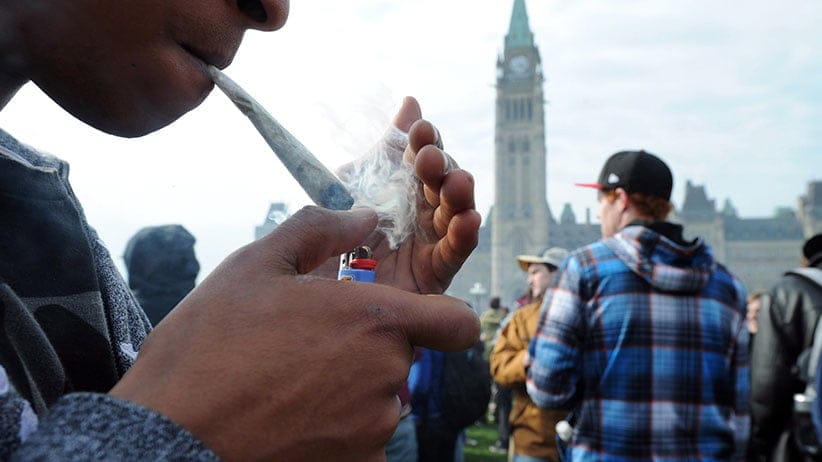 A protester lights a joint during a 4-20 marijuana rally on Parliament Hill in Ottawa on Friday, April 20, 2012. (Sean Kilpatrick/CP)