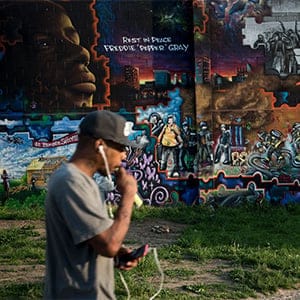 A man walks past a mural dedicated to Freddie Gray April 25, 2016 in Baltimore, Maryland, a year after the protests that were sparked by Gray's death in police custody. Baltimore agreed last year to pay a $6.4 million settlement with the family of Freddie Gray, whose death in custody sparked riots and looting in the gritty city located near the US capital Washington.  (Brendan Smialowski/AFP/Getty)