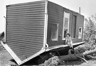 Betty Walsh peers through a broken window into a neighbours cabin on June 3 1985, during a cleanup operation in Barrie, Ont. The cabin was overturned by one of several tornadoes that ripped through southern Ontario north of Toronto, killing a dozen and leaving hundreds homeless. Walsh was blown out of her own home onto her front lawn but was not injured. (Tim Clark/Getty Images)