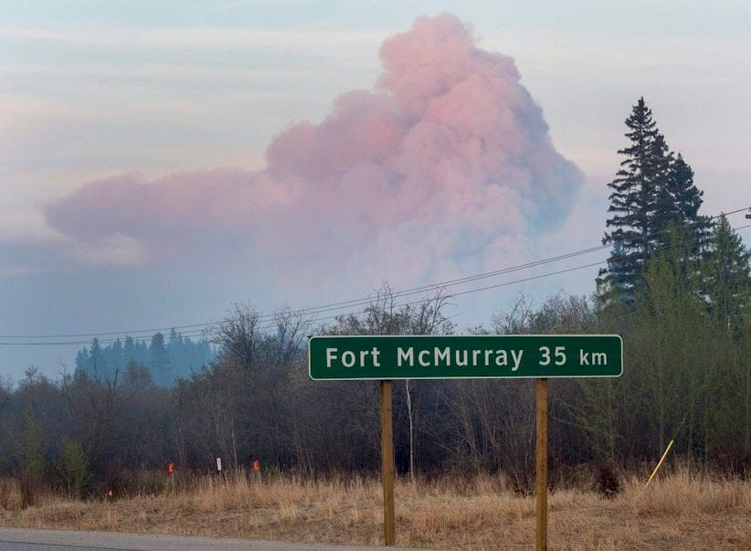 A massive plume of smoke rises from a wildfire burning out of control near the highway to Fort McMurray, Alberta Friday, May 6, 2016.THE CANADIAN PRESS/Ryan Remiorz