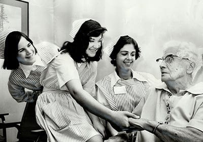 Teenage Volunteers at Toronto Western Hospital give their attention to 81-years-old patient Mrs. Williamina Bruce. The girls; all 14 years old; are from left; Sara Carr; Marinella Sovran and Sandra Fant. The young volunteers are wearing the pink and white uniforms from which they get their name candy-stripers. (Bob Olsen/Toronto Star/Getty Images)