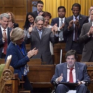 Ottawa-Vanier MP Mauril Belanger, who lives with ALS (also known as Lou Gherig's disease) uses a tablet with text-to-speech program to defend his proposed changes to neutralize gender in the lyrics to "O Canada" in the House of Commons on Parliament Hill in Ottawa on Friday, May 6, 2016. The lyrics to O Canada will be a hot topic in Ottawa on Tuesday, even though the July 1 fireworks are still a month away.The House of Commons is debating an effort by dying Liberal Mauril Belanger to render the national anthem gender-neutral, by replacing the line in the English version "in all thy sons command" with "in all of us command." (Adrian Wyld/CP)