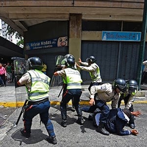 Security forces clash with people trying to reach Miraflores presidential palace to protest against the severe food and medicine shortages, in Caracas on June 2, 2016.
Venezuelans face long lines at supermarkets tightly guarded by nervous soldiers, bare shelves and soaring prices inside, a dysfunctional health care system short on basic medications and supplies, daily power cuts of four hours across most of the country, and a government that only operates two days a week to save electricity. (Juan Barreto/AFP/Getty Images)