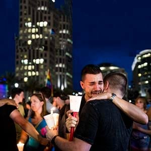 Mourners comfort eachother at a vigil in ORlando on June 13th, 2016. (Photograph by Roger Kisby/Redux)