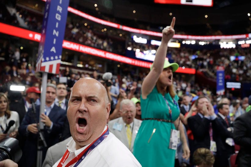 Illinois delegate Christian Gramm, left, and other delegates react as some call for a roll call vote on the adoption of the rules during first day of the Republican National Convention in Cleveland, Monday, July 18, 2016. (AP Photo/John Locher)
