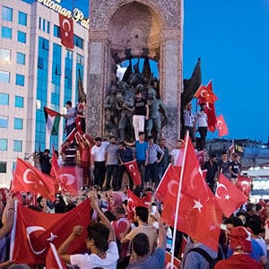 The day after a failed coup attempt in Turkey, supporters of President Recep Tayyip Erdogan and his AK Party gather at Taksim Square for a "Democracy festival", climbing onto the iconic monument of Mustafa Kemal Ataturk, modern Turkey's founder.   The fallout from the failed coup has left Turkey more divided than ever between Islamists and secularists. (Photograph by Adnan Khan)
