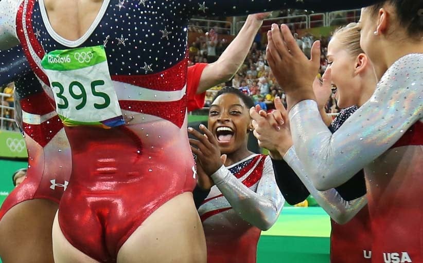 2016 Rio Olympics - Artistic Gymnastics - Final - Women's Team Final - Rio Olympic Arena - Rio de Janeiro, Brazil - 09/08/2016. Simone Biles (USA) of USA (C) celebrates with team mates following her floor routine during the women's team final. Team USA won gold in the event. (Mike Blake/Reuters)